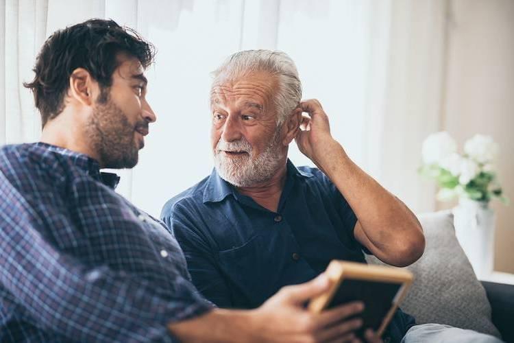 photo of a younger man showing a tablet to an older man